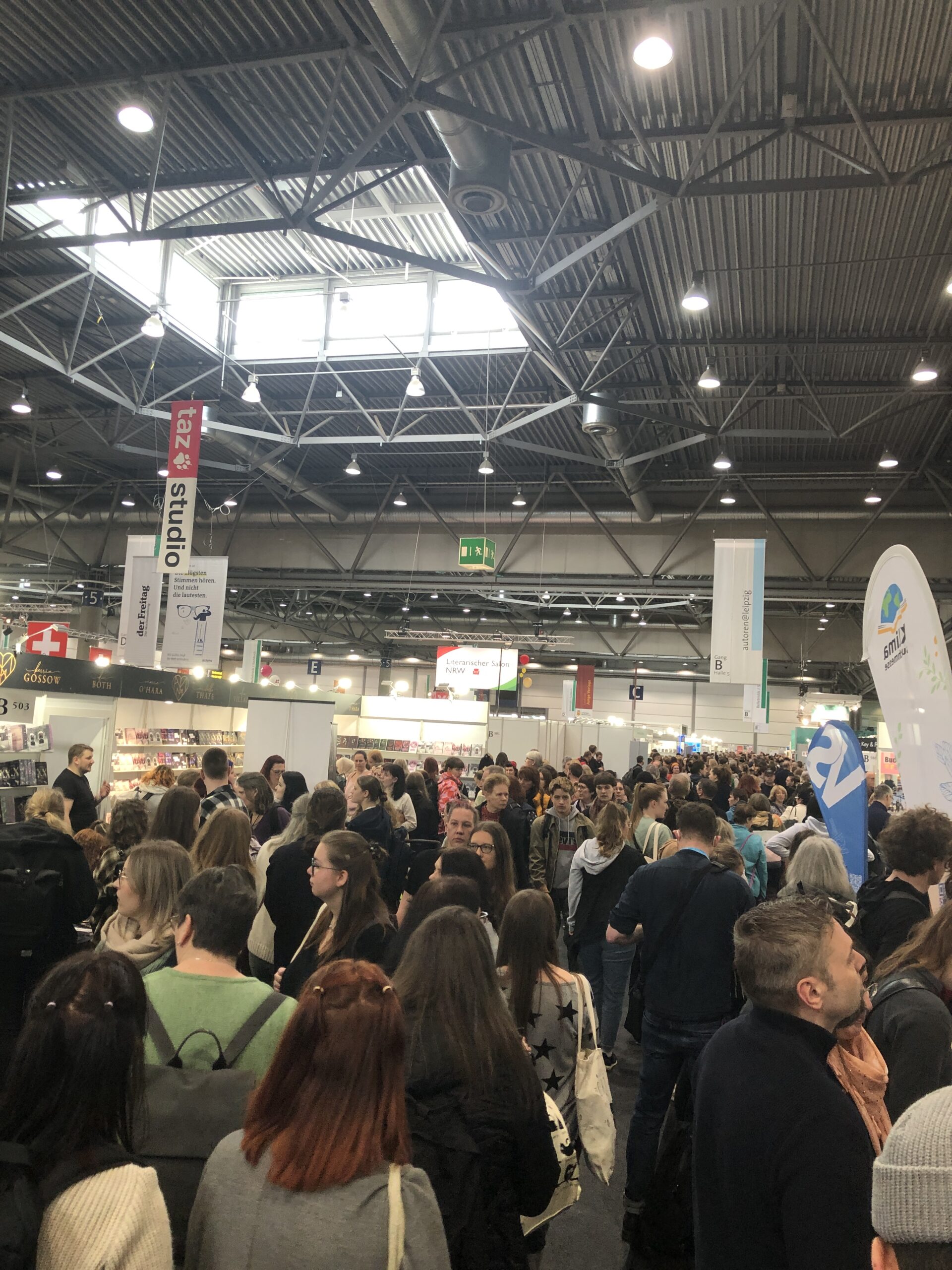 Ein Gang auf der Leipziger Buchmesse voll mit Menschen, die Bücher lieben