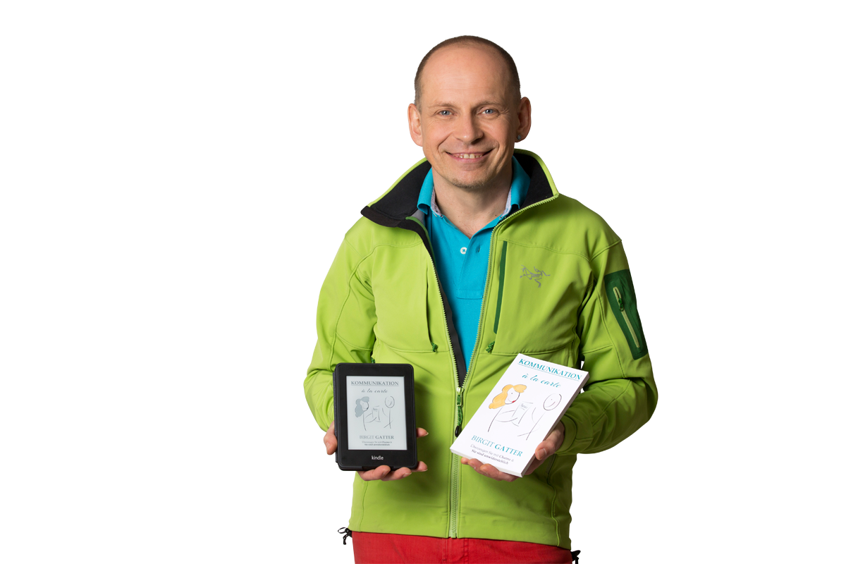 Buchmentor tom Oberbichle mit einem Kindle eReader und einem Taschenbuch